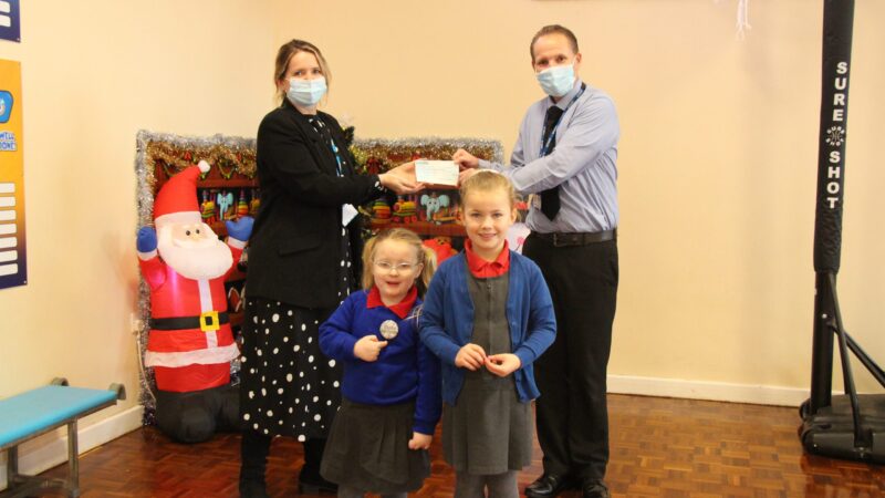 Headteacher Mark Atkinson hands over cheque to fundraising coordinator Suzi Campbell. Pupils Lucy Robinson and Thea Wass stand with them.