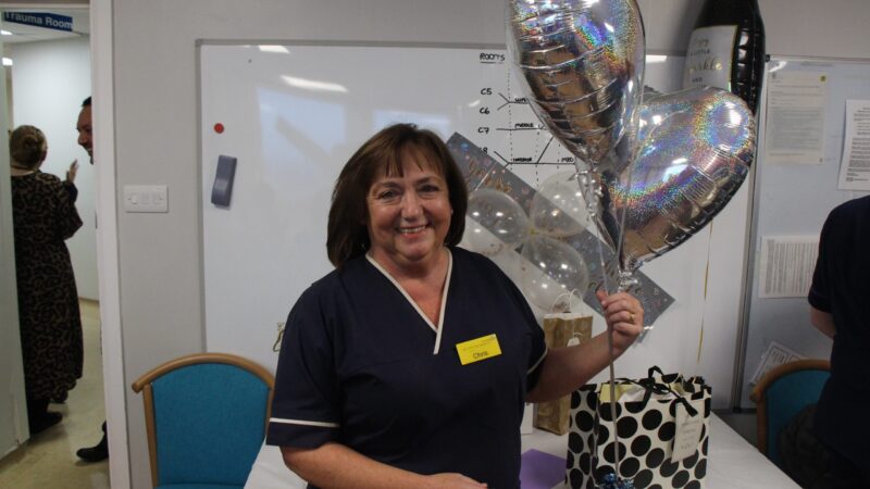 Chris Kemp holds balloons at her retirement party.