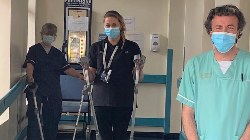 Members of staff holding crutches.