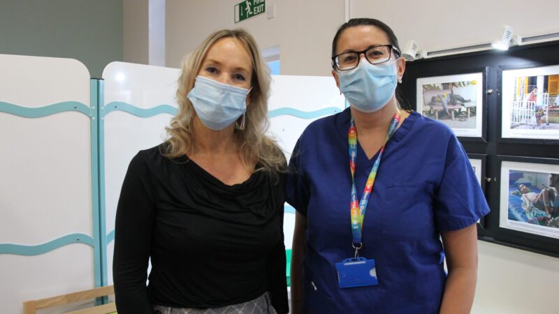 Michelle Curries stands in the vaccination clinic with her vaccinator.