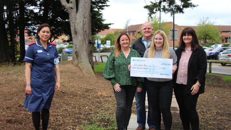 Matron Monette Baldonasa stands with the family. One of them holds a giant cheque.