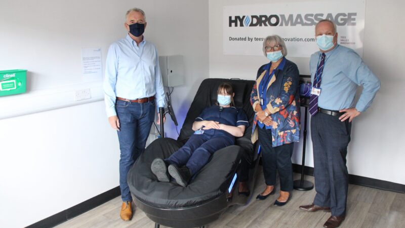 A member of staff sits on the massage chair.