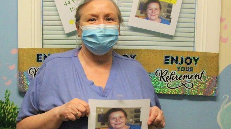 Margaret Carter. She holds a photo of herself from her younger days.