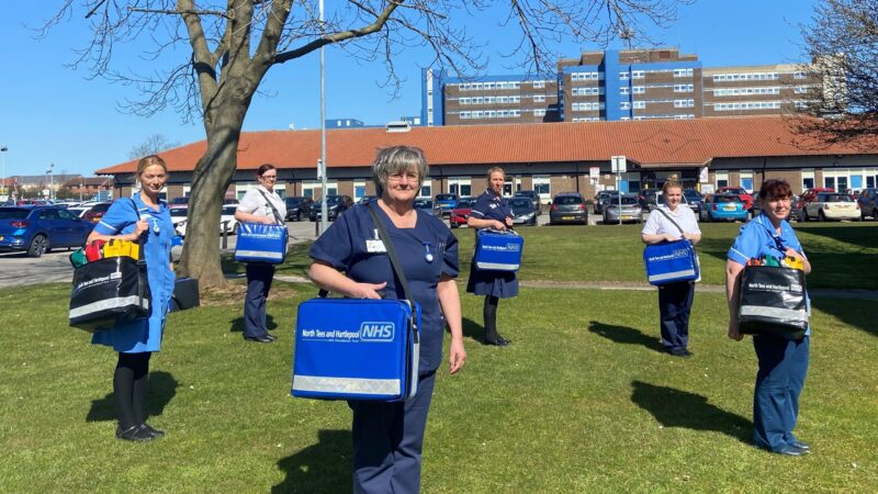 Staff hold their community kit bags.