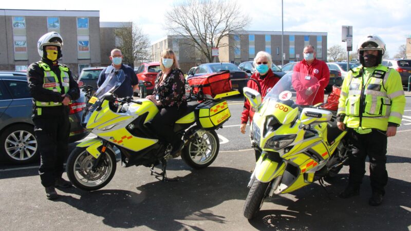 The Bloodrun team stand with two motorbikes.