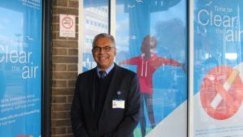 Deepak Dwarakanath stands in front of stop smoking sign