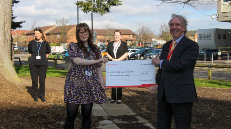 Staff from SGP Accountants outside the University Hospital of North Tees. Two of them hold a giant cheque.
