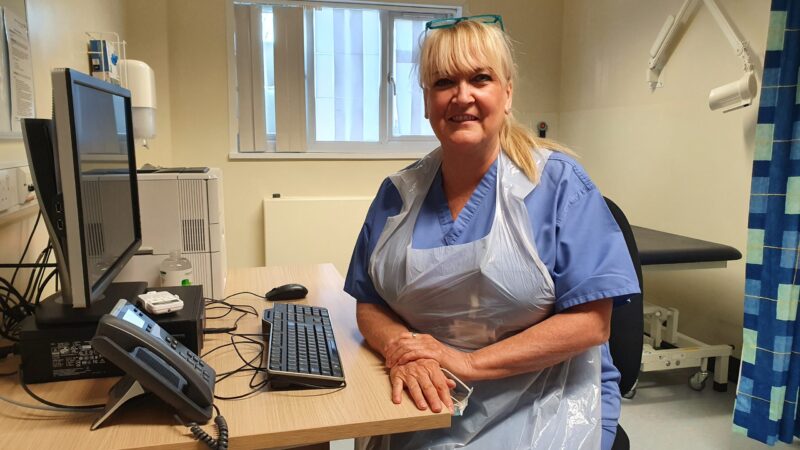 Jeanette Polson sits at a desk.