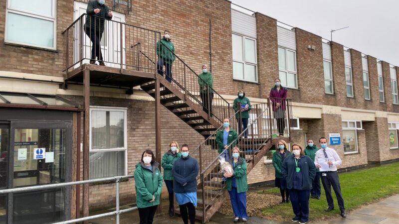 The palliaitve care team. One of them holds a hamper.