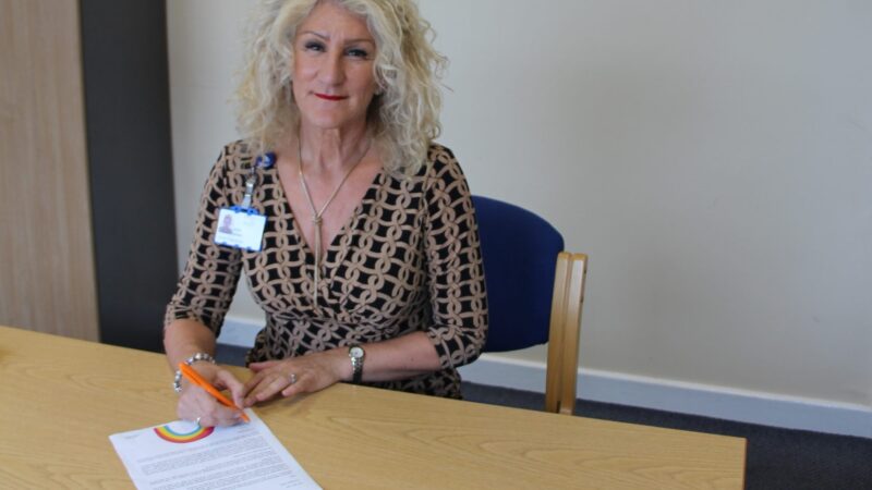 Julie Gillon signing a letter.