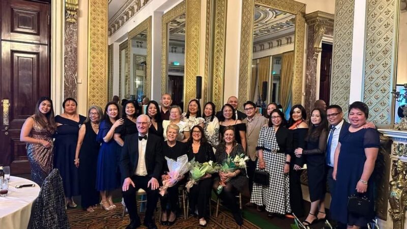 A group photo of all nurses at the event. They wear evening gowns and suits.