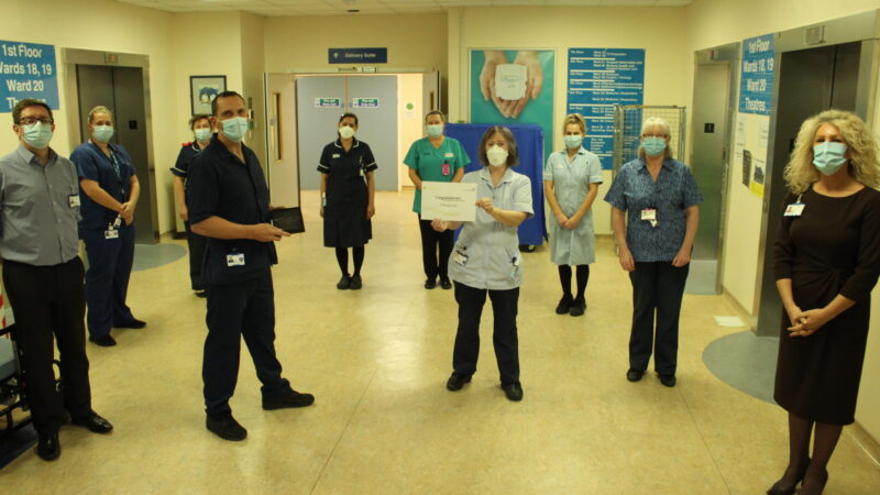 The critical care team and Julie Gillon. A member of the team holds a certificate, another holds a trophy.